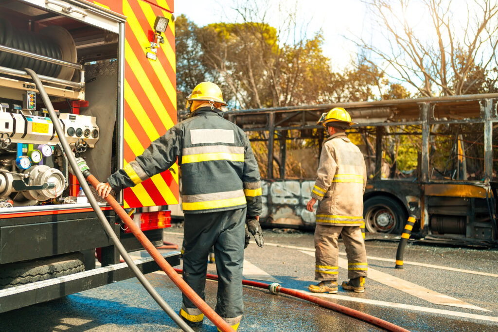 3 firemen standing behind the fire truck